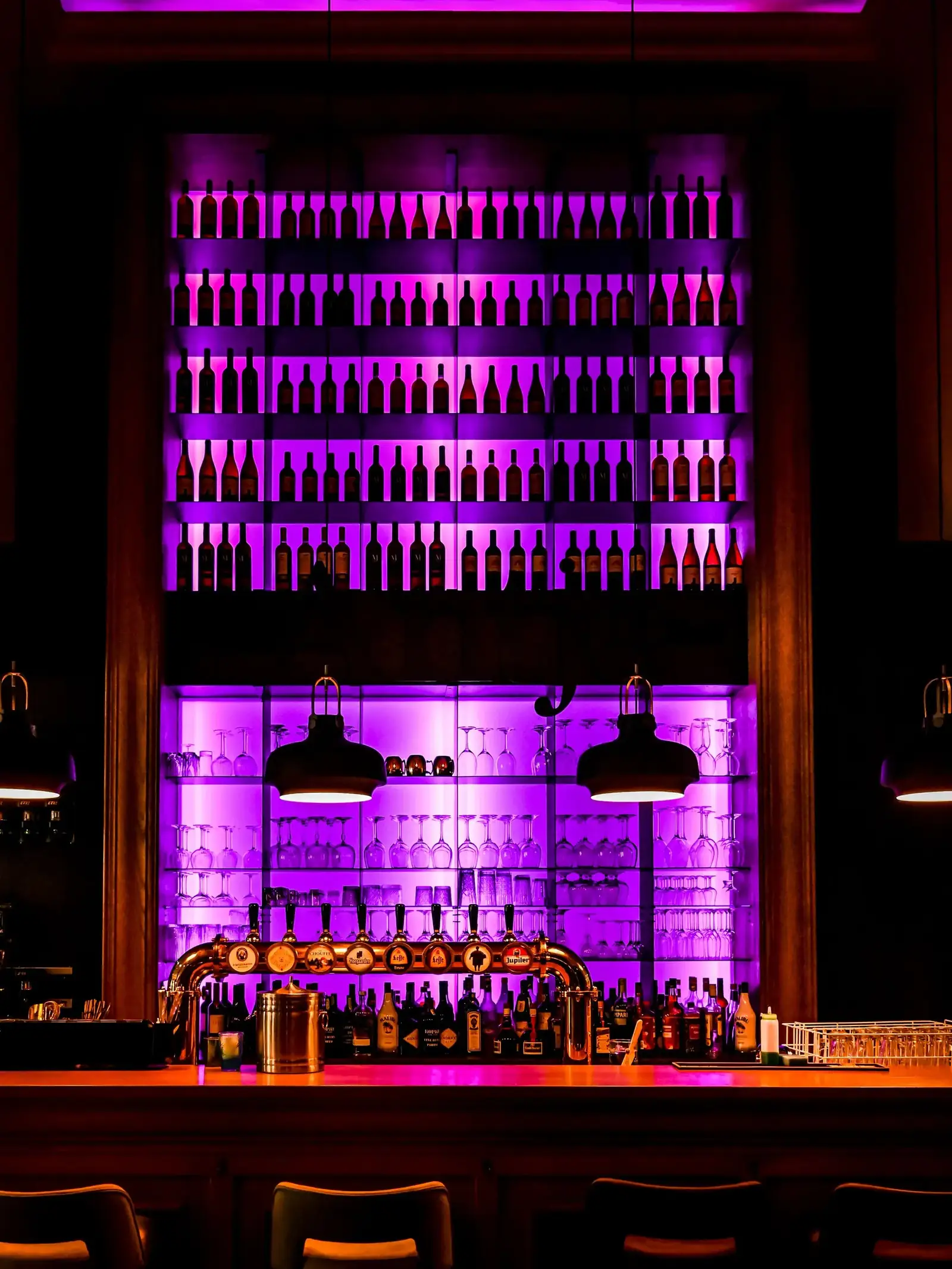 Beleuchtetes Flaschenregal der Cocktailbar Mojo am Abend