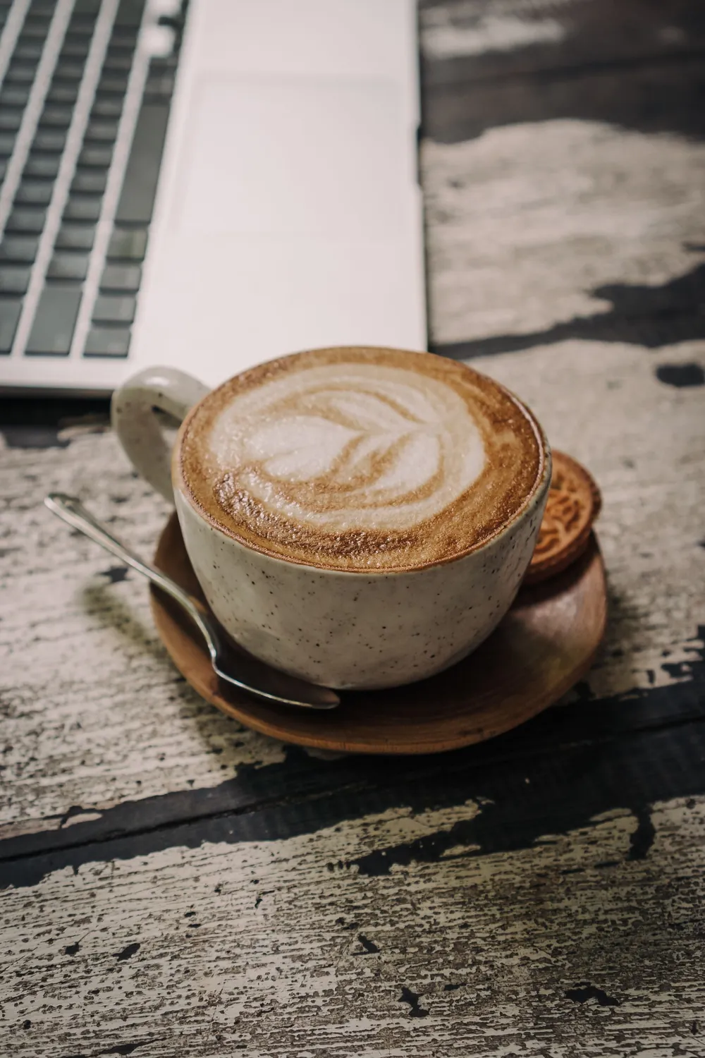 Kaffee mit Latte-Art auf dunklem Holztisch