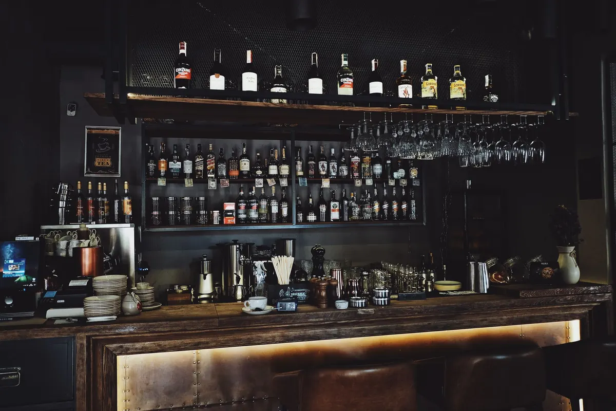 Bar mit beleuchtetem Flaschenregal am Abend